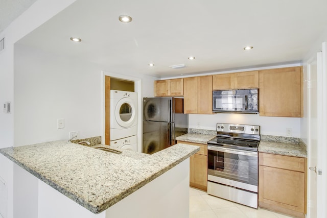 4221 W Mcnab Rd Unit 28, Pompano Beach, FL 33069 - kitchen featuring a peninsula, a sink, stacked washer and clothes dryer, light stone counters, and black appliances