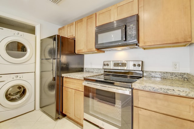 4221 W Mcnab Rd Unit 28, Pompano Beach, FL 33069 - kitchen featuring light brown cabinets, light tile patterned floors, light stone countertops, black appliances, and stacked washer and dryer