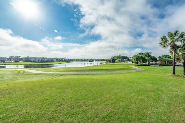 view of home's community featuring golf course view, a yard, and a water view