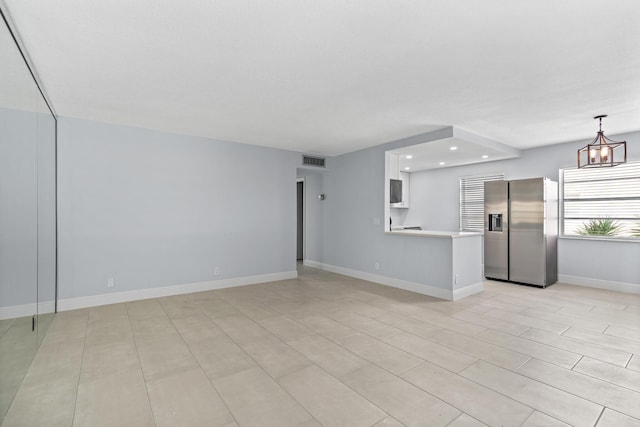 unfurnished living room with baseboards, visible vents, and recessed lighting