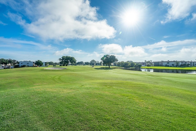 view of community with a yard, golf course view, and a water view