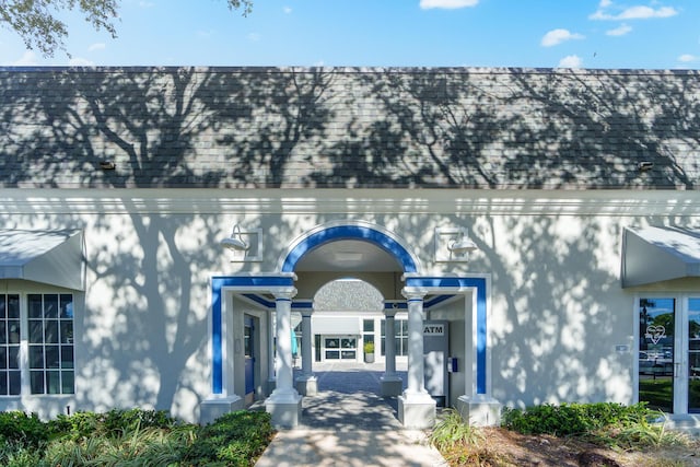 property entrance featuring roof with shingles