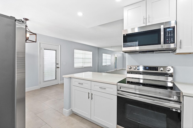 kitchen featuring stainless steel appliances, a peninsula, light tile patterned flooring, white cabinetry, and light countertops