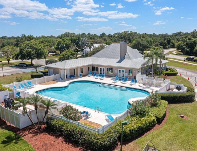 665 NE Bent Paddle Ln, Port Saint Lucie, FL 34983 - community pool with a yard, a patio, fence, and french doors