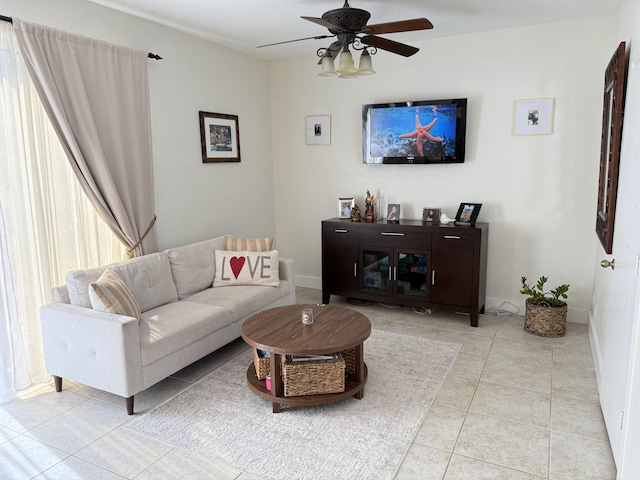 living room with a ceiling fan, baseboards, and light tile patterned flooring