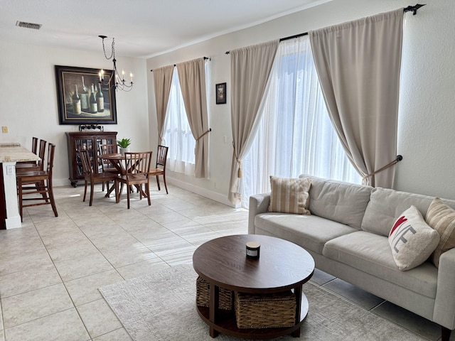 living area featuring visible vents, plenty of natural light, light tile patterned floors, and a notable chandelier