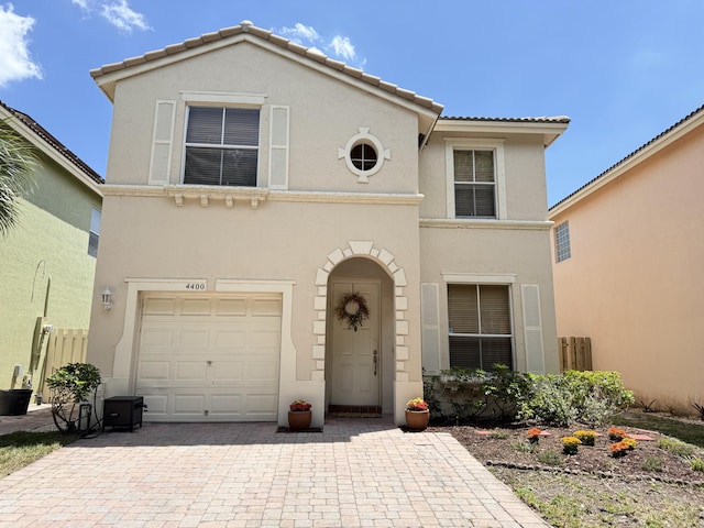 view of front of house with an attached garage, decorative driveway, stucco siding, and a tile roof