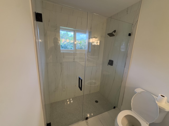 bathroom with toilet and a marble finish shower