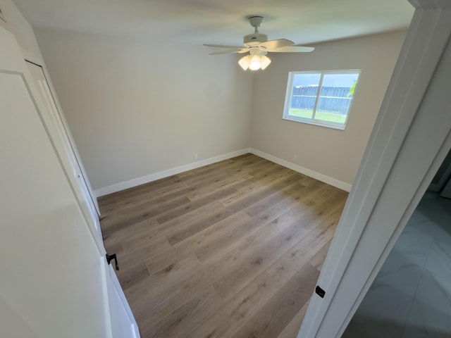 unfurnished bedroom with wood finished floors, baseboards, and ceiling fan
