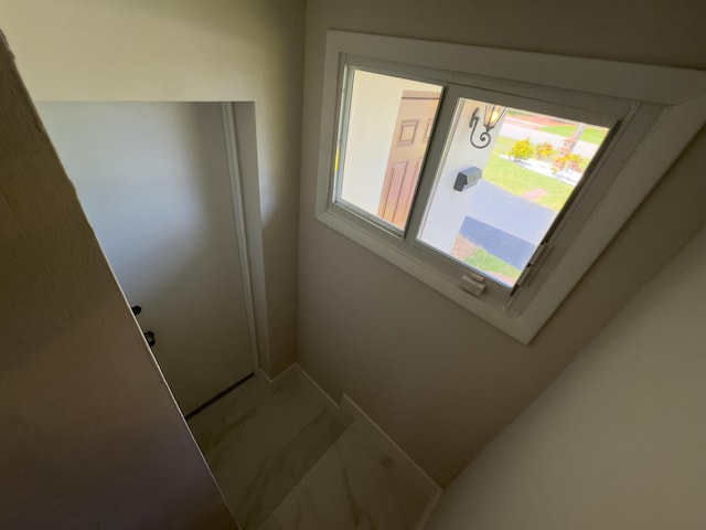 interior space featuring marble finish floor and baseboards