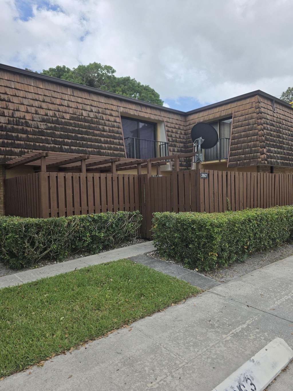 2601 26th Ln, Greenacres, FL 33463 - view of home's exterior with a fenced front yard and mansard roof