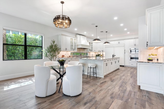 10343 S Barnsley Dr, Parkland, FL 33076 - dining area featuring light wood-type flooring, a chandelier, and recessed lighting