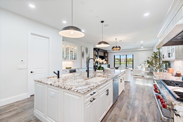 10343 S Barnsley Dr, Parkland, FL 33076 - kitchen with stove, light wood-type flooring, white cabinetry, stainless steel dishwasher, and recessed lighting