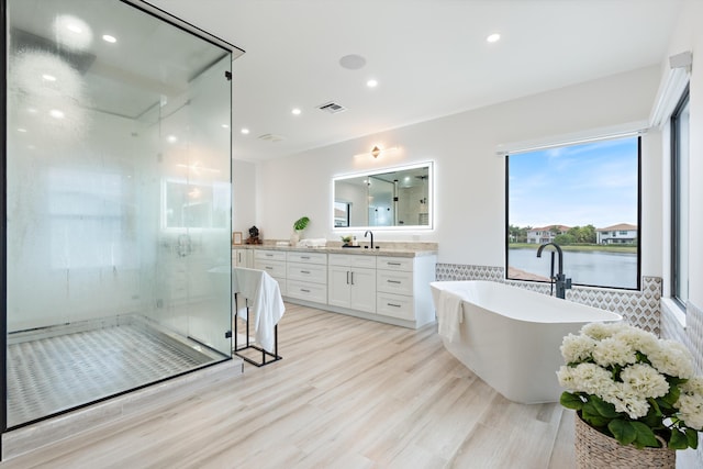 10343 S Barnsley Dr, Parkland, FL 33076 - full bath featuring vanity, a soaking tub, a shower stall, wood finished floors, and recessed lighting