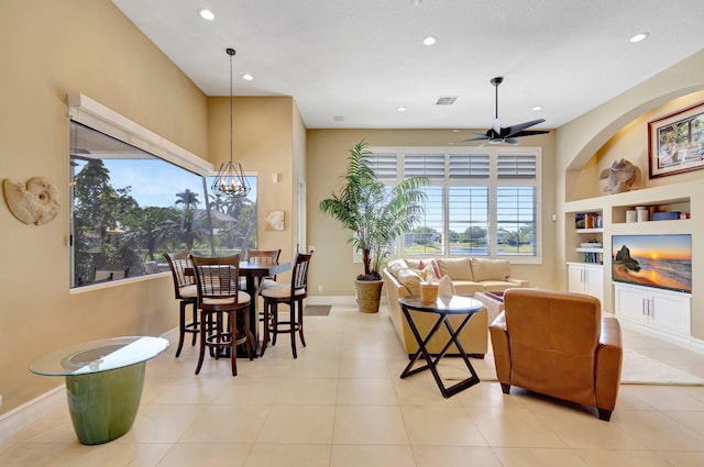 living area with built in shelves, ceiling fan with notable chandelier, recessed lighting, baseboards, and visible vents