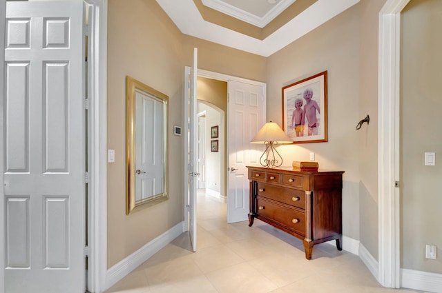 hallway with crown molding, arched walkways, and baseboards