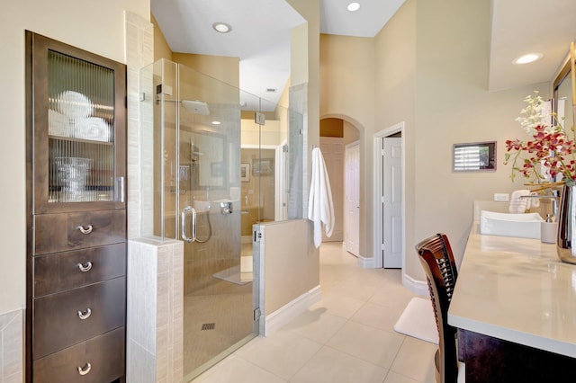bathroom featuring tile patterned floors, baseboards, a shower stall, and vanity