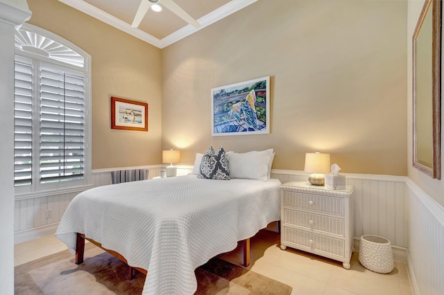 bedroom with crown molding, tile patterned floors, and a wainscoted wall