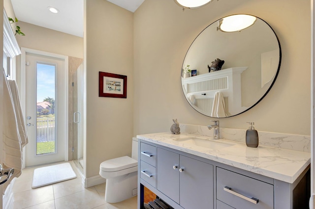 full bathroom with a stall shower, vanity, tile patterned floors, baseboards, and toilet