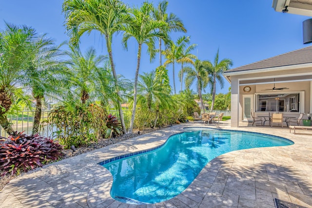pool with fence private yard, ceiling fan, and a patio area