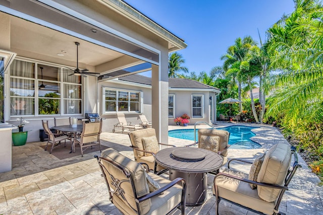 view of patio with a ceiling fan, an outdoor pool, and outdoor dining space