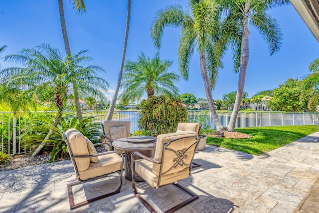 view of patio / terrace featuring a water view and fence