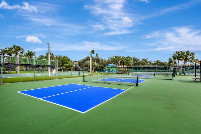 view of sport court featuring fence and playground community