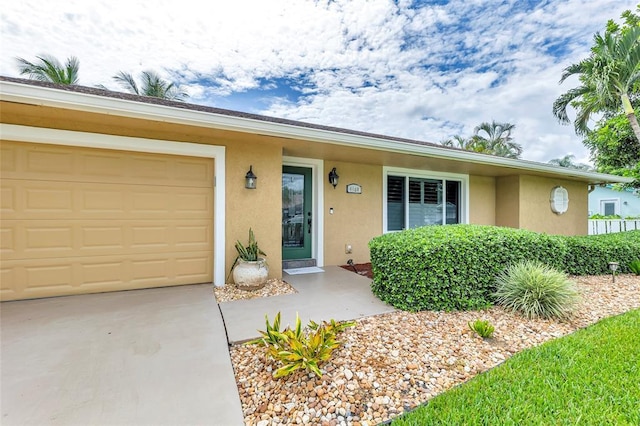 4160 Juniper Ter, Boynton Beach, FL 33436 - view of front of house featuring stucco siding, concrete driveway, and a garage