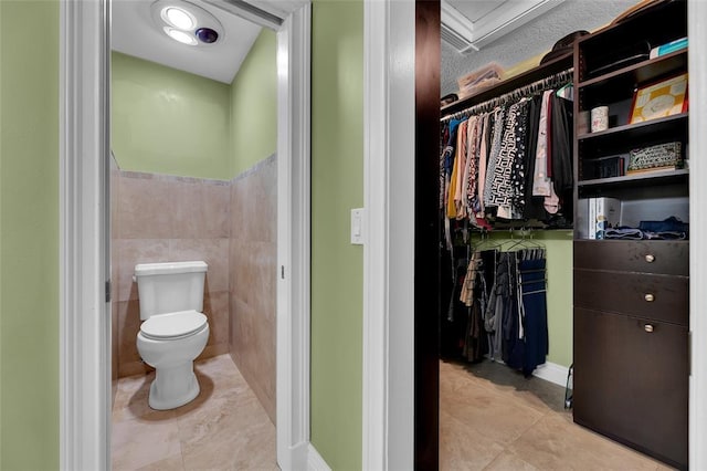 4160 Juniper Ter, Boynton Beach, FL 33436 - bathroom featuring a walk in closet, toilet, and tile patterned floors