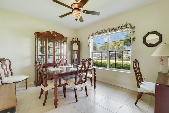 dining room with light tile patterned floors, baseboards, and ceiling fan