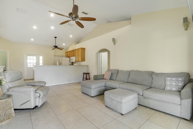 living area featuring arched walkways, a ceiling fan, light tile patterned flooring, and lofted ceiling