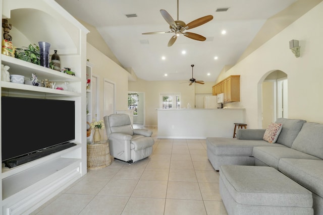 living area featuring light tile patterned flooring, arched walkways, visible vents, and a ceiling fan