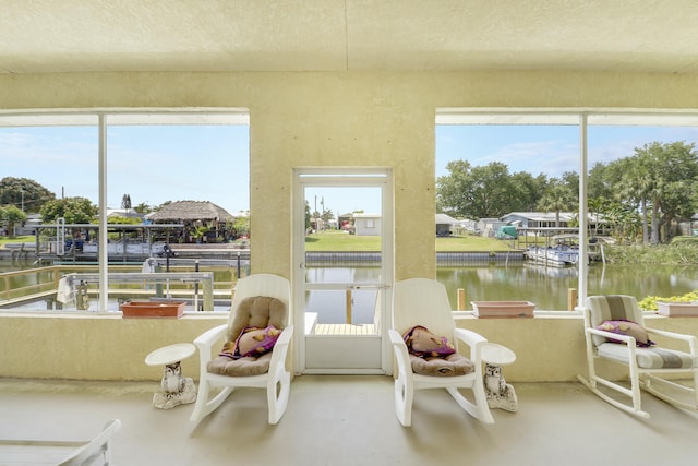 sunroom / solarium featuring a water view