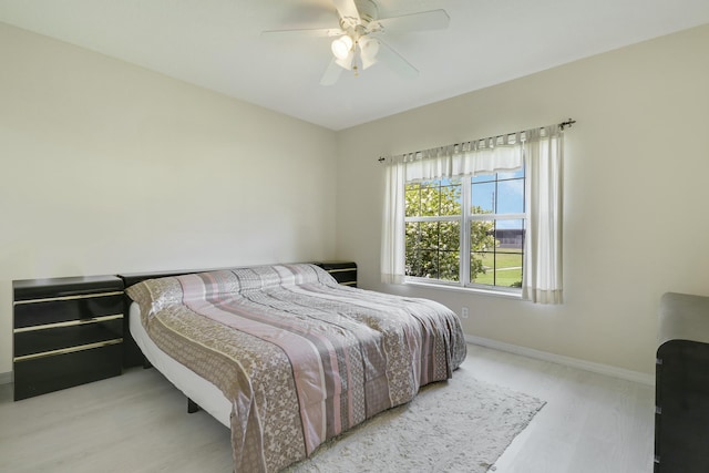 bedroom featuring baseboards, a ceiling fan, and wood finished floors