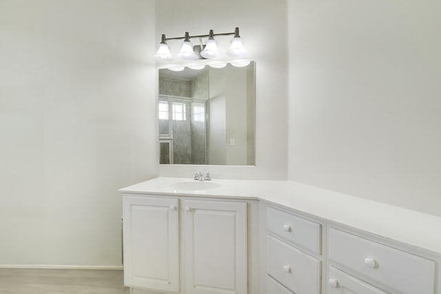 bathroom featuring baseboards, vanity, and wood finished floors