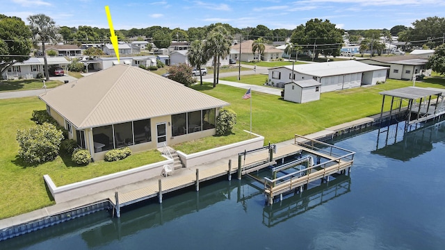 dock area featuring a yard, a residential view, a water view, and boat lift