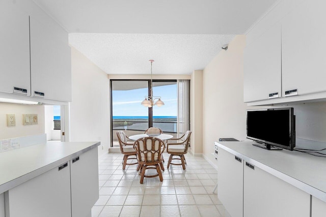 100 Lakeshore Dr Unit 1557, North Palm Beach, FL 33408 - kitchen with an inviting chandelier, light countertops, white cabinets, and baseboards