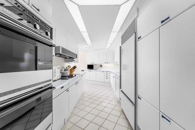 100 Lakeshore Dr Unit 1557, North Palm Beach, FL 33408 - kitchen with double oven, black electric stovetop, white cabinets, light countertops, and wall chimney exhaust hood
