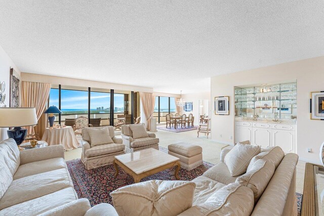 100 Lakeshore Dr Unit 1557, North Palm Beach, FL 33408 - living room with a textured ceiling, a notable chandelier, carpet, and baseboards