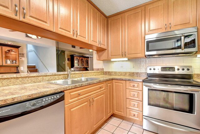 3718 Victoria Dr, West Palm Beach, FL 33406 - kitchen featuring stainless steel appliances, a sink, light countertops, and light tile patterned flooring