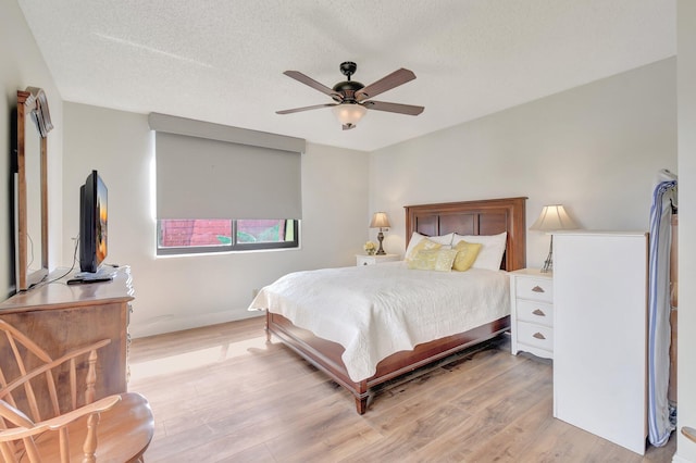 3718 Victoria Dr, West Palm Beach, FL 33406 - bedroom with light wood-style flooring, ceiling fan, a textured ceiling, and baseboards