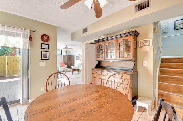 3718 Victoria Dr, West Palm Beach, FL 33406 - dining area featuring a ceiling fan, light tile patterned flooring, stairs, and a textured ceiling