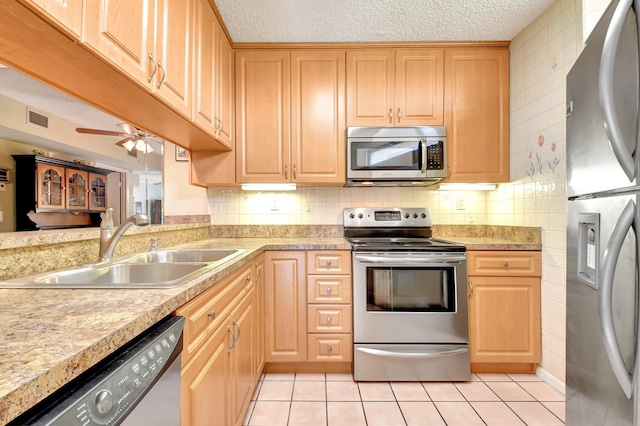 3718 Victoria Dr, West Palm Beach, FL 33406 - kitchen with appliances with stainless steel finishes, a sink, light countertops, a textured ceiling, and light brown cabinetry
