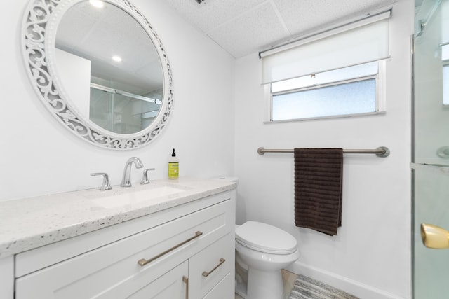 full bathroom with toilet, baseboards, a shower stall, and vanity