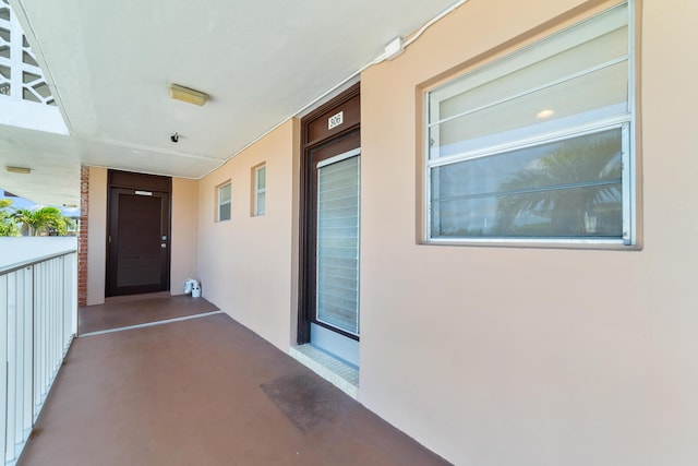 doorway to property with stucco siding and a balcony