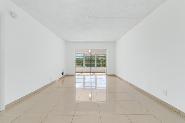 unfurnished room featuring baseboards and light tile patterned flooring