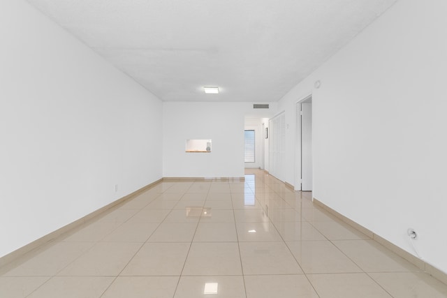 spare room featuring visible vents, baseboards, and light tile patterned floors