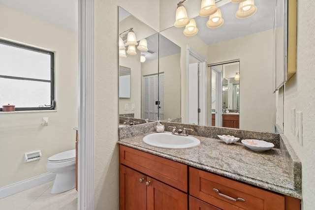 bathroom with tile patterned flooring, baseboards, toilet, and vanity