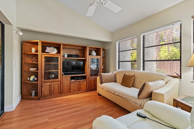 living room with baseboards, ceiling fan, light wood-type flooring, and lofted ceiling