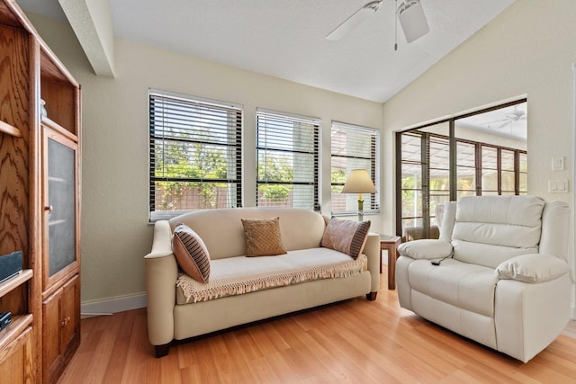 interior space with baseboards, ceiling fan, vaulted ceiling, and wood finished floors